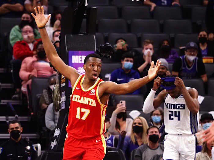 Onyeka Okongwu holds his arms up in the air after a dunk.